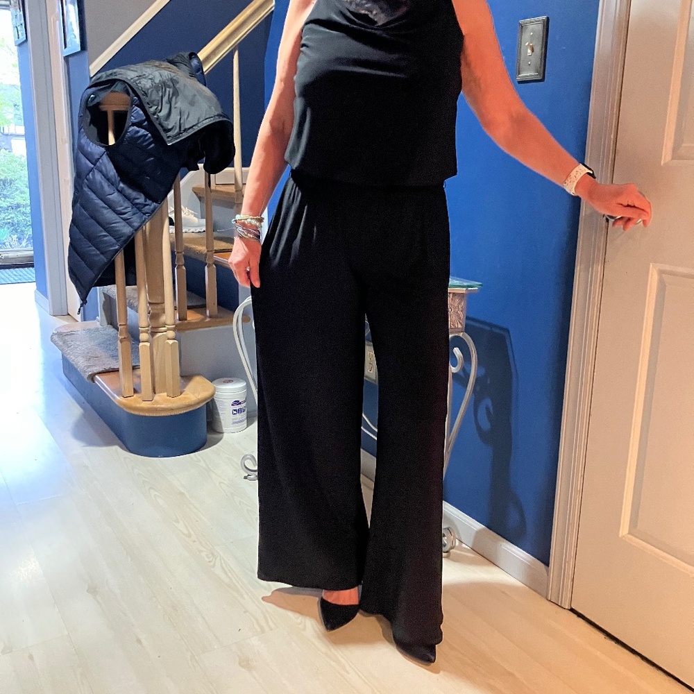 Flattering, flowing black jump suit draped front with lace accent on top.